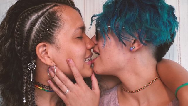 Slow motion tender kiss between young lesbian couple. Long and short hair. Hot kiss between girlfriends. Love last forever. Proud to be gay.