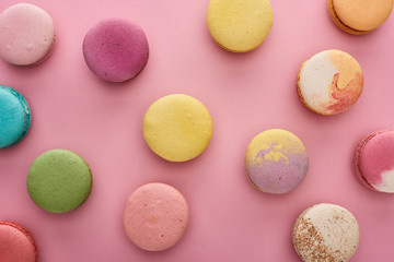 background pattern with multicolored delicious French macaroons on pink