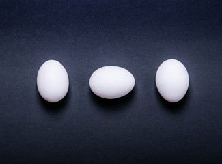 White eggs on black background