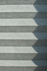 Folded textile window blind lit by sunlight closeup as background