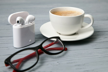 Cup of coffee, glasses and headphones
