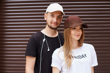 Handsome guy in a yellow cap and black t-shirt near a metal wall