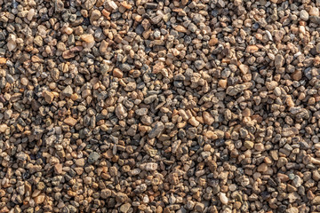 Beautiful horizontal texture of yellow and gray small pebbles and stones is in the photo