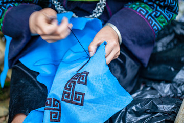 embroidery with patterns on clothes close-up, woman's hands embroidering a pattern on fabric