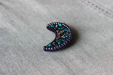 embroidered bead brooch in the form of the moon on a blue background