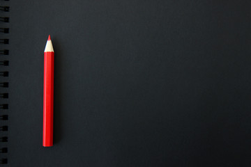red pencil on black background. Space for text or logos