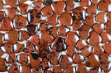 Bulk of mahogany obsidian heart-shaped stones texture background