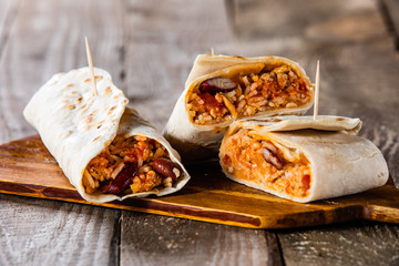 Burritos on cutting board on wooden table