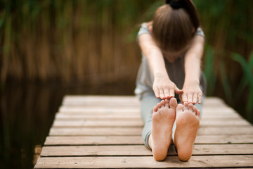 Child doing exercise on platform outdoors. Healthy lifestyle. Yoga girl