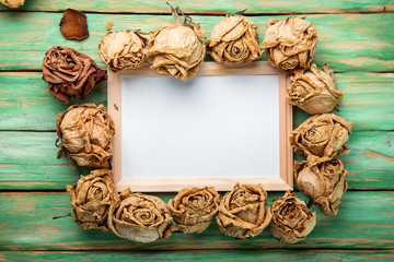 Photo frame with dried flowers  roses on wooden background