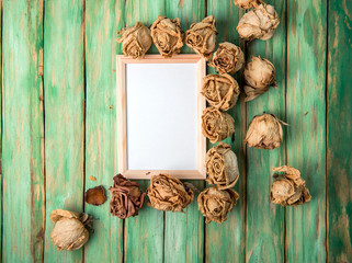 Photo frame with dried flowers  roses on wooden background