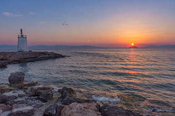 Fototapeta na wymiar Old small lighthouse of the Aegina island, Saronic gulf, Greece, at sunset.