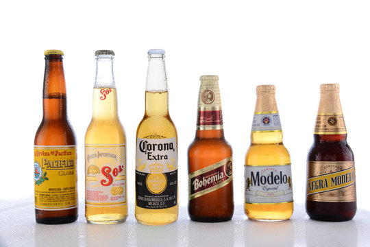 IRVINE, CA - JUNE 14, 2015: Popular Mexican Beers. Pacifico, Sol, Corona, Bohemia and Modelo beer bottles on a wet table with reflections. 