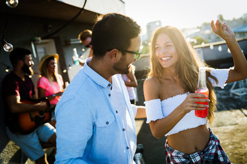 Happy young dancing couple having fun and enjoying party at summer