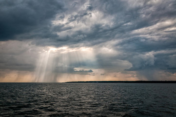 Naklejka premium Dramatic sea landscape with rainy clouds