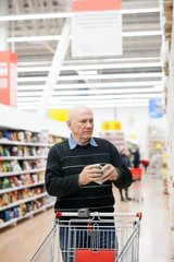 man with   trolley buying groceries in   store