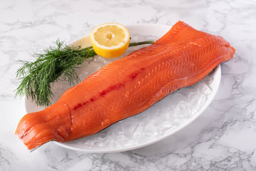 whole raw salmon fillet on marble background