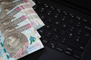 Polish money, banknotes with the highest denomination of 500 zlotys lying on a computer keyboard