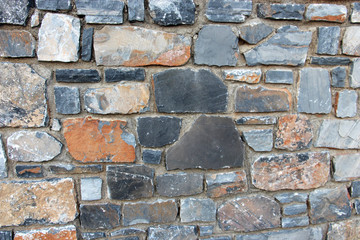 old background with strong thick walls of colored stones bonded with cement