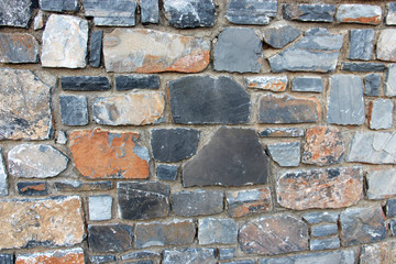 old background with strong thick walls of colored stones bonded with cement