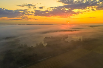 Morning fog over a lake while the sun is rising.