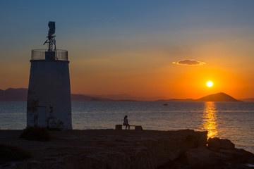 Old small lighthouse of the Aegina island, Saronic gulf, Greece, at sunset.