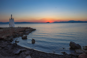Old small lighthouse of the Aegina island, Saronic gulf, Greece, at sunset.
