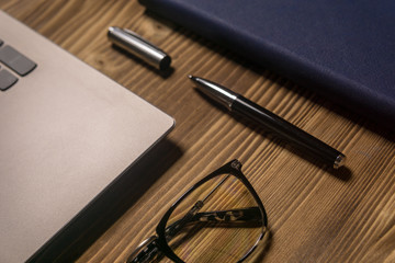 Notebook, laptop, glasses and pen on the table. Concept of business or study.