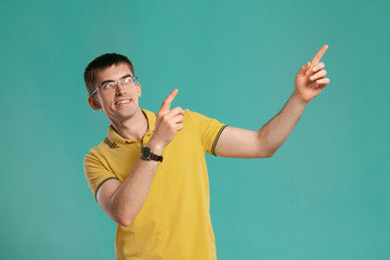 Handsome guy in a yellow casual t-shirt is posing over a blue background.