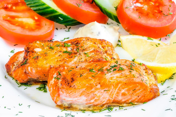 grilled salmon with lemon, white plate, top view