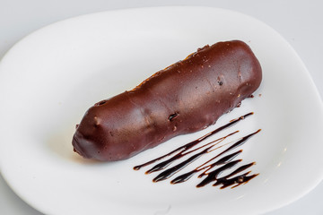 Three eclairs with chocolate isolated on white background. Top view