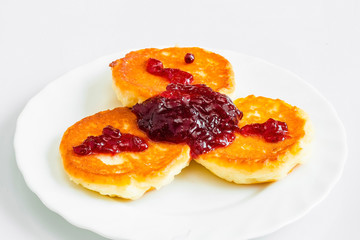 Homemade cheesecakes with red jam, white background, breakfast, top view