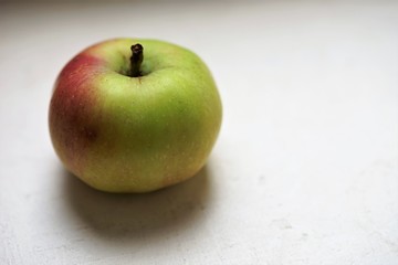 ripe green red apple on the white table
