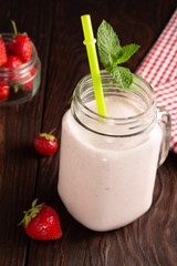 Strawberry yogurt with fresh strawberries on a dark rustic wooden background, top view