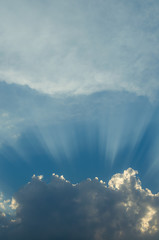 Optimistic sunset rays behind the clouds. Glow in the sky. Symbol of light. Beautiful scene of...