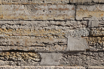 Old stone wall with cracks, natural concrete background, old natural texture of an ancient stone. It is used for decoration of buildings and embankments, a wonderful background for the desktop 