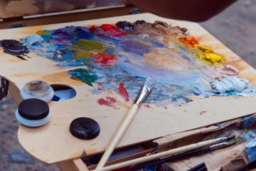 painter's brush, stained with different bright color paints, rest after plainair painting session...