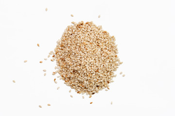 Top view of sesame seeds scattered on white paper