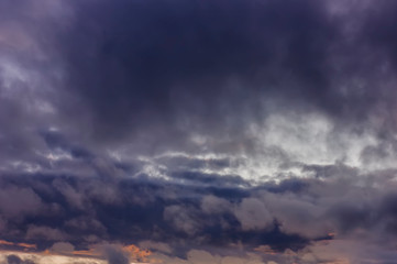 Dark rain clouds during sunset. Dramatic sky during sunset. Dark storm clouds with black and white highlights.