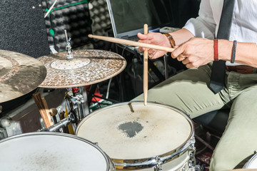 Detail of the hands of a man playing the drums.