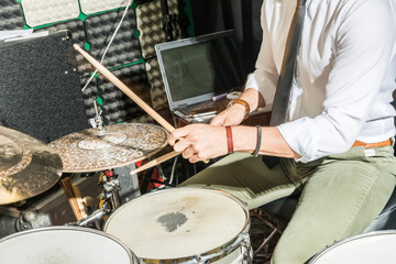 Detail of the hands of a man playing the drums.