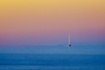 White sailing boat approching on the sea
