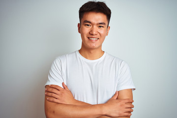 Obraz premium Young asian chinese man wearing t-shirt standing over isolated white background happy face smiling with crossed arms looking at the camera. Positive person.