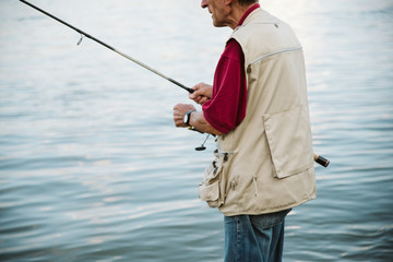 An older man fishing on a river