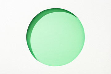 cut out round hole in white paper on lime green colorful background