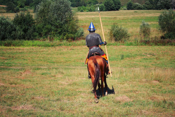 An ancient equestrian in historical costume ride a horse