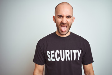 Young safeguard man wearing security uniform over isolated background sticking tongue out happy...