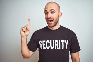 Young safeguard man wearing security uniform over isolated background pointing finger up with...