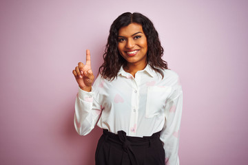 Transsexual transgender businesswoman standing over isolated pink background showing and pointing up with finger number one while smiling confident and happy.