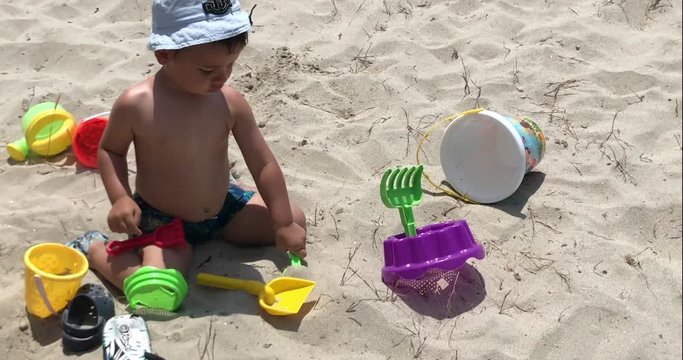 Child playing with bucket and shovel on the beach